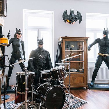 Drei als Batman verkleidete Personen spielen Schlagzeug.