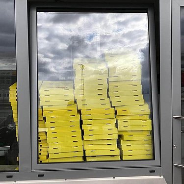 Day 35: yellow pizza boxes in the shop window