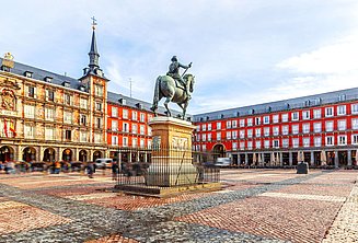 Plaza Mayor with equestrian statue and people walking on the square