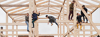 wooden house construction with some architects inside
