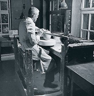 Porcelain worker at work, forming a teapot