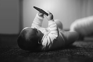 [Translate to englisch:] Baby with Smartphone in the hand